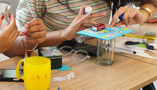 Hands creating something using recycled materials